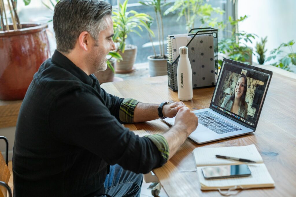 Erstgespräch im Ablauf eines Website-Projekts: Videocall am Laptop im Büro