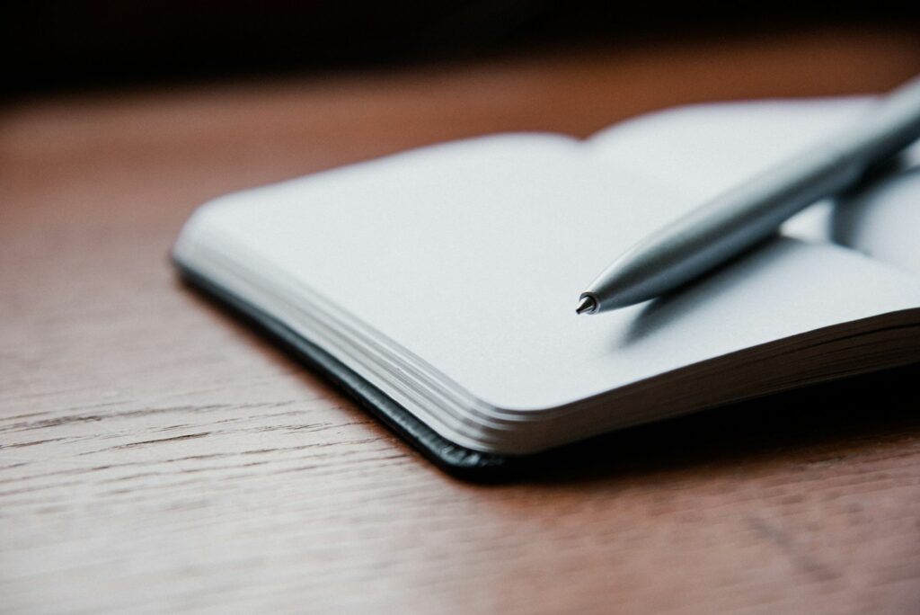Vorbereitung auf das Website-Projekt: Notizbuch und Stift für die Liste der Leistungen und Kundenfragen